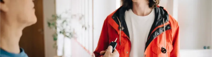 Un père remet des clés de voiture à son fils.