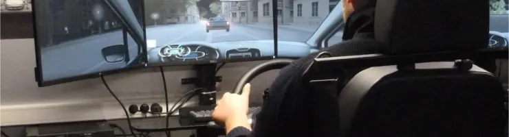 Un homme utilise un simulateur de conduite avec trois écrans affichant une scène de rue.