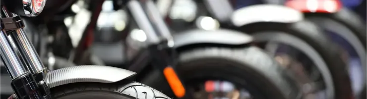 Un gros plan sur les roues avant et les phares de plusieurs motos alignées, mettant en valeur leur design.