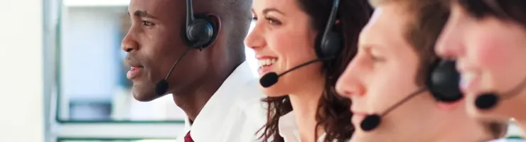 Groupe diversifié de conseillers client souriants et équipés de casques.