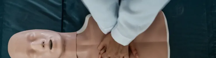 Formation aux premiers secours : une personne effectue un massage cardiaque sur un mannequin.
