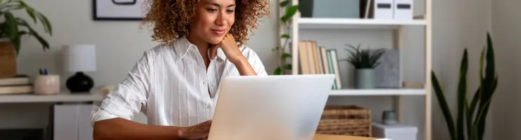 Une femme assise à une table, utilisant un ordinateur portable.