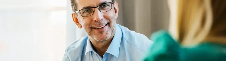 Conseiller souriant échangeant avec une cliente lors d'un rendez-vous.