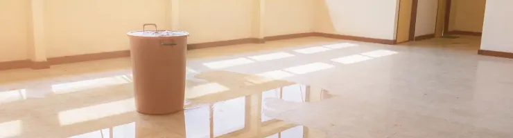 Pièce vide avec sol inondé suite à un dégât des eaux.