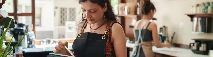Commerçante travaillant sur un ordinateur dans sa boutique.
