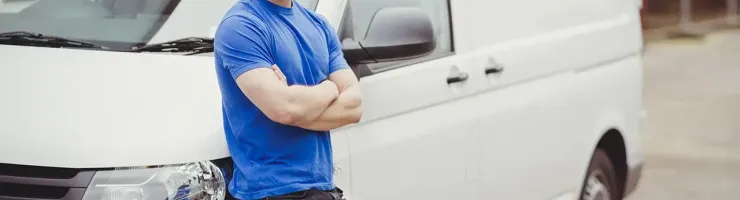Technicien de maintenance devant un véhicule utilitaire.