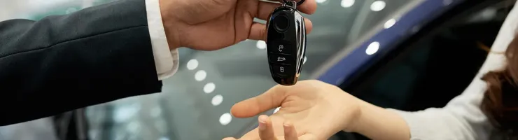 Une personne remet une clé de voiture à une autre personne dans un échange amical.