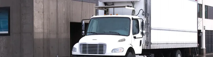 Camion utilitaire stationné devant un bâtiment
