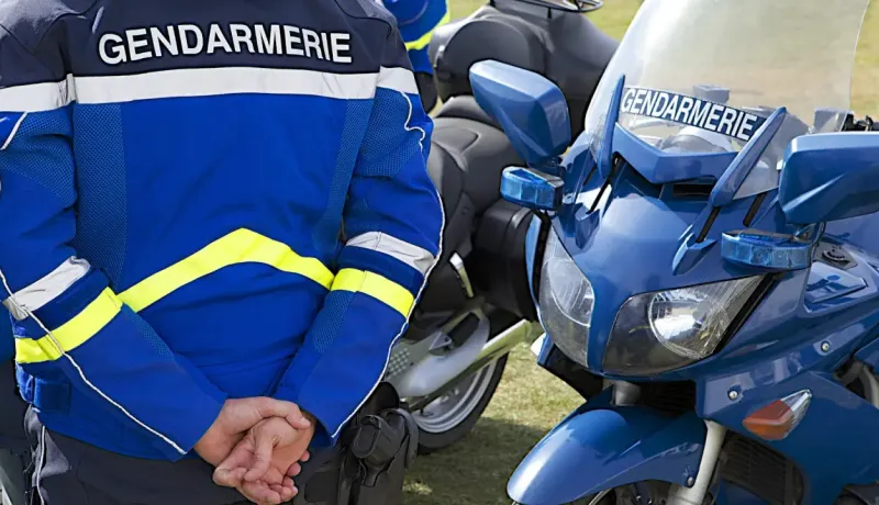 Gros plan d'un gendarme et de sa moto.