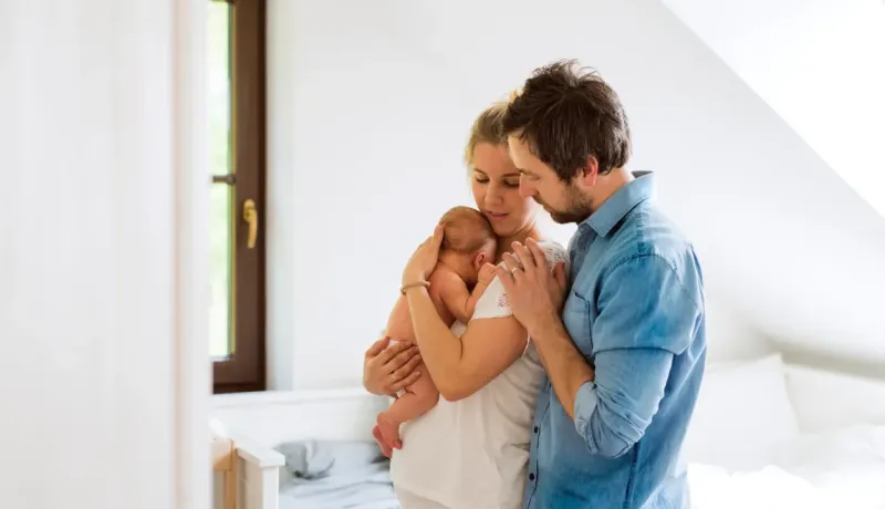 Un couple en train de passer du temps avec leur bébé, moment de soutien et de complicité.