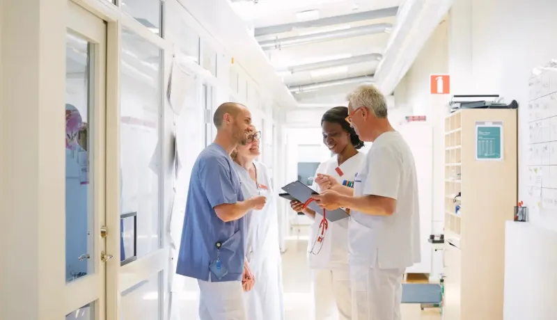 Du personnel médical discute ensemble dans un couloir de l'hôpital.