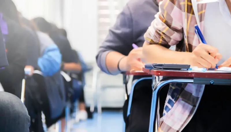 Étudiants en train de passer un concours sur table.