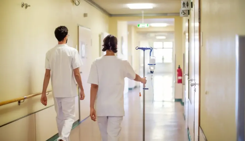 Du personnel médical marche dans un couloir.