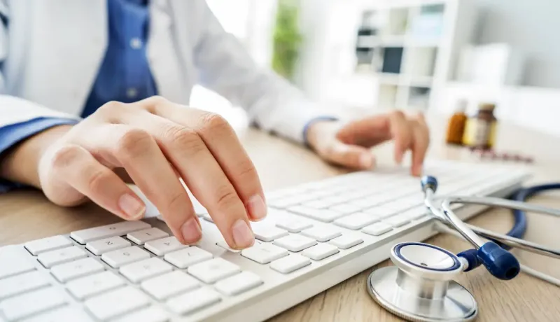 Mains de médecin tapant sur un clavier, travail de bureau et productivité.