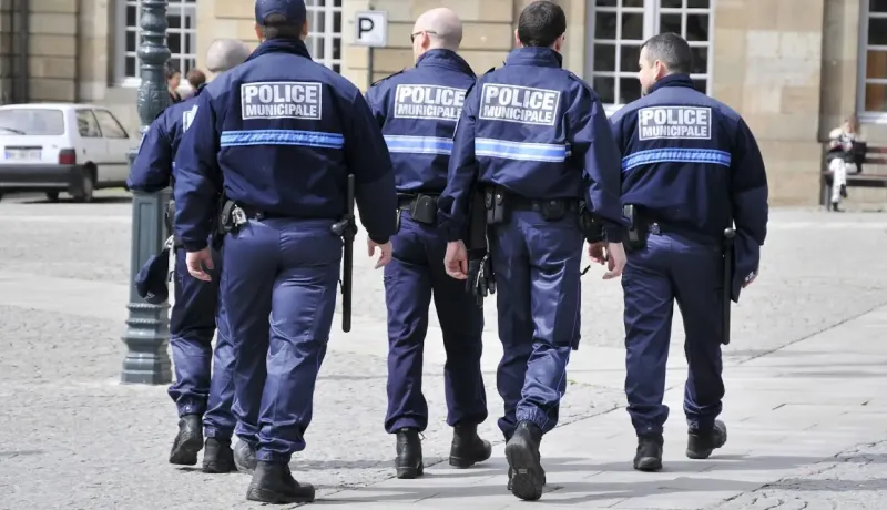 Une équipe de policiers marche dans la rue.
