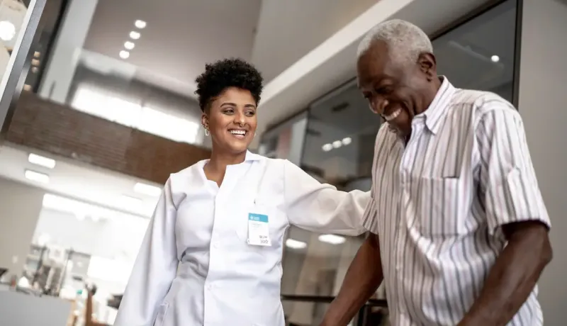 Un médecin discute avec un patient souriant âgé 