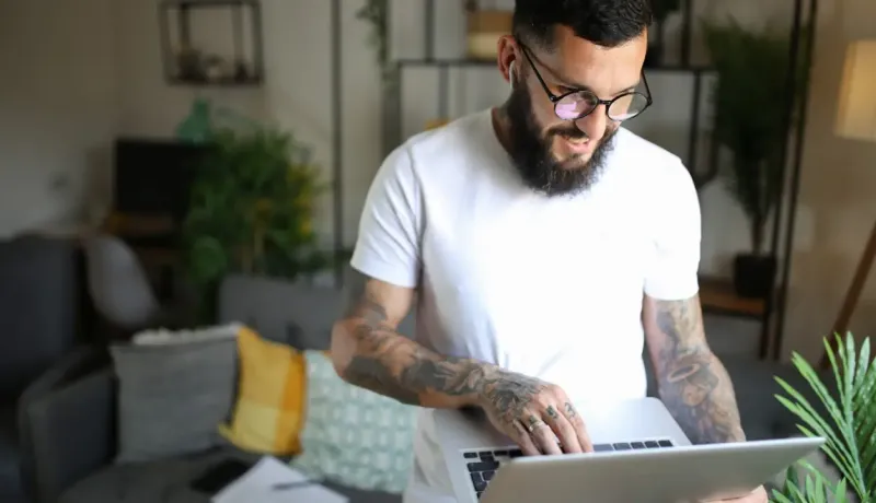 Une homme compare les crédits sur un ordinateur portable.