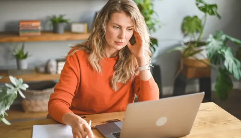 Femme travaillant sur son ordinateur portable à domicile.