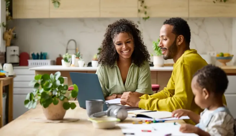 Un couple consulte un ordinateur portable dans une cuisine.