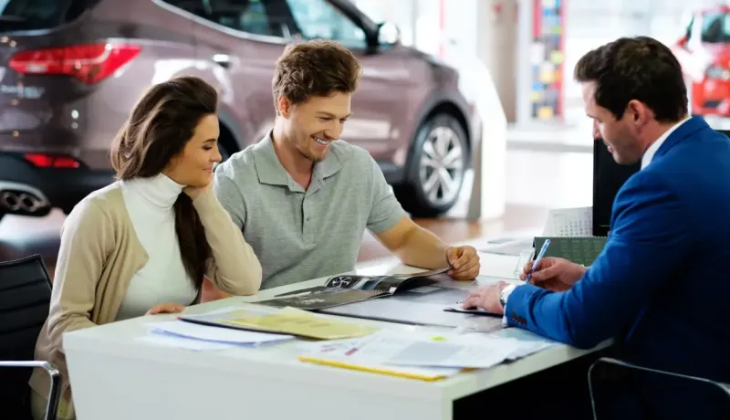 Un couple est en train de choisir un véhicule avec un conseiller automobile
