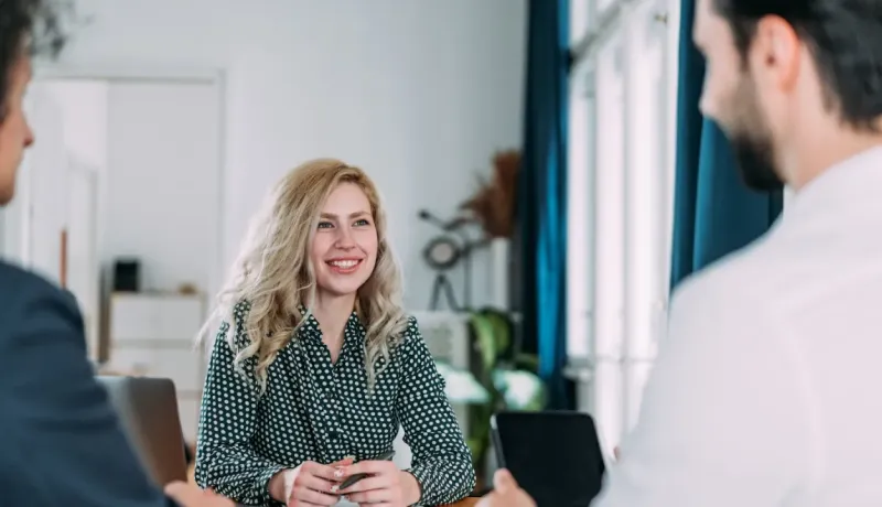 Une conseillère échangeant avec un couple de sociétaires lors d'un rendez-vous.