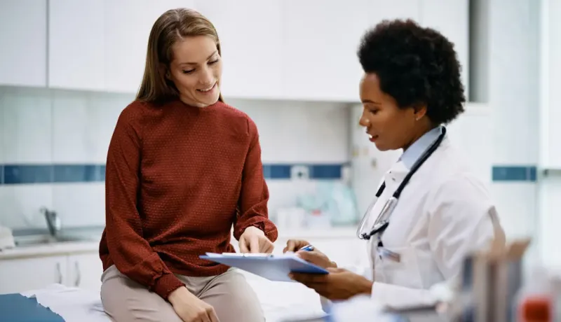 Médecin et patiente examinant un document, consultation médicale.