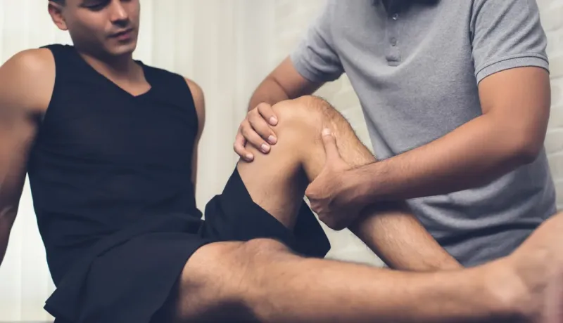 Thérapeute aidant un patient avec un exercice de physiothérapie du genou.