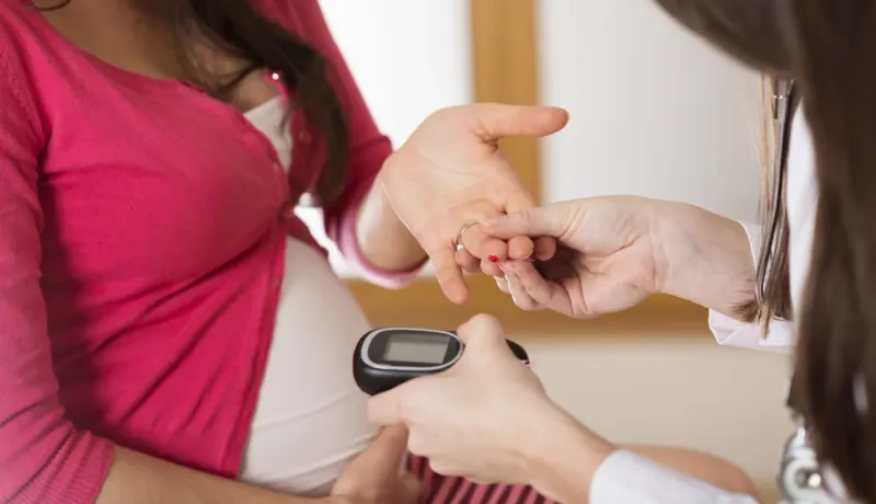 Un professionnel de la santé vérifie la glycémie d'une femme enceinte.
