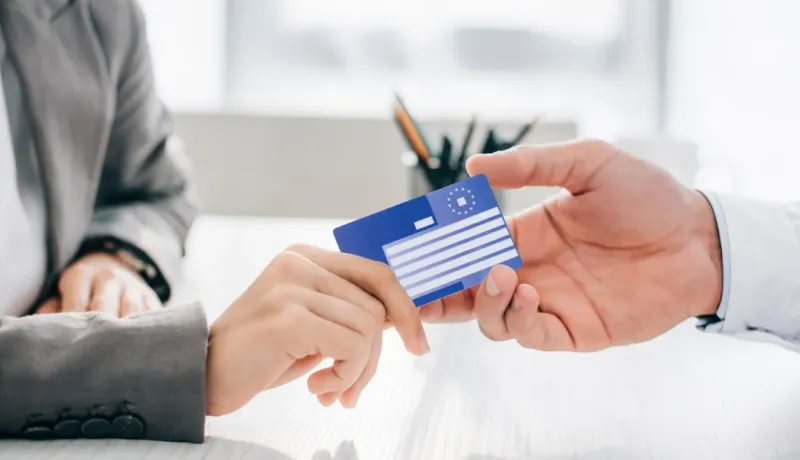 Échange d'une carte européenne d'assurance maladie bleue entre deux personnes.