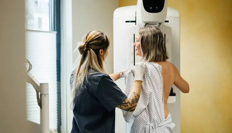 Une technicienne médicale aide une femme lors d'une mammographie, un examen de dépistage du cancer du sein.