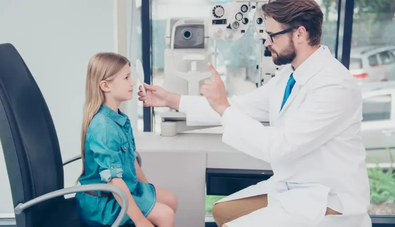 Ophtalmologiste examinant la vision d'une jeune fille.