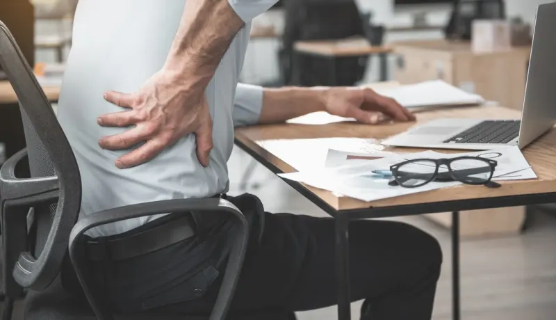Homme au bureau souffrant de mal de dos, se tenant le flanc.