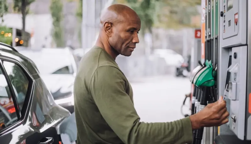 Un homme à une station-service utilise sa carte bancaire pour payer.