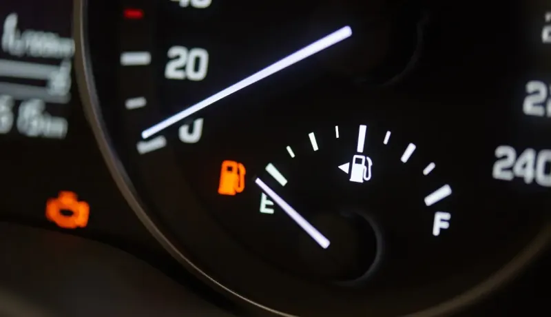 Tableau de bord de voiture avec l'indicateur de niveau de carburant presque vide.