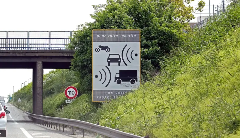 Un panneau de signalisation français avertissant des contrôles radars pour motos, voitures et camions.