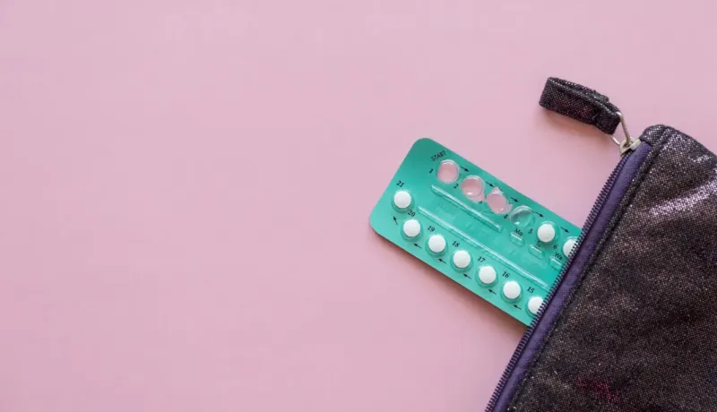 Plaquette de pilules contraceptives sortant d'une trousse.