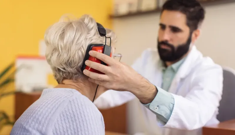 Un professionnel de santé équipe un patient pour un test d'audition.