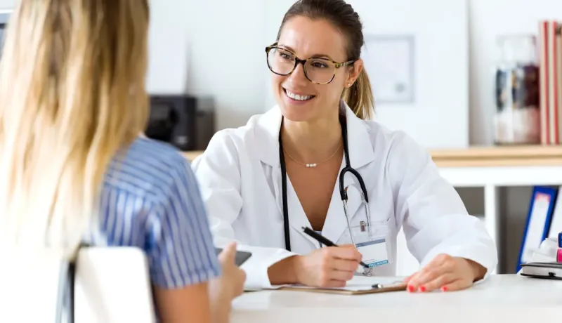 Une femme médecin souriante s'entretient avec sa patiente.