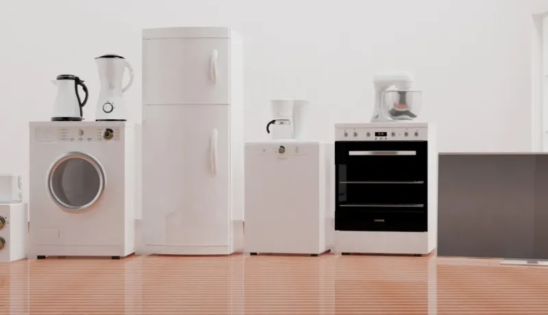 Alignement d'appareils électroménagers neufs blancs (lave-linge, réfrigérateur, lave-vaisselle, four) dans une pièce claire.