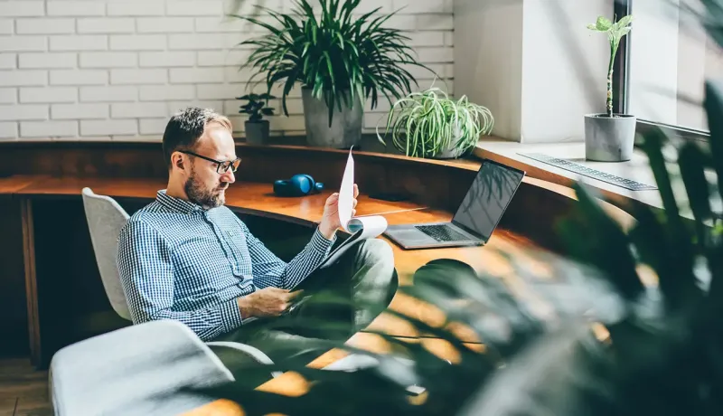 Un homme assis à un bureau, utilisant un ordinateur portable.