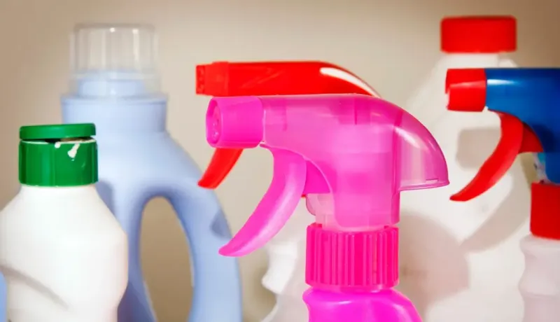 Gros plan sur des sprays de produits ménagers colorés.