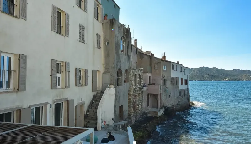 Façade de maisons anciennes construites directement au bord de l'eau.