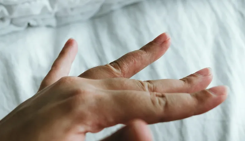 Un doigt humain tendu avec une plaque rouge 