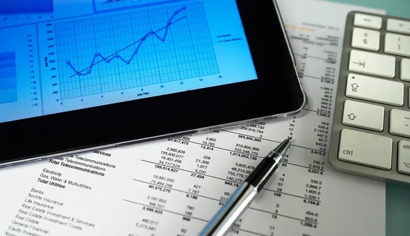 Analyse de documents financiers avec ordinateur portable.