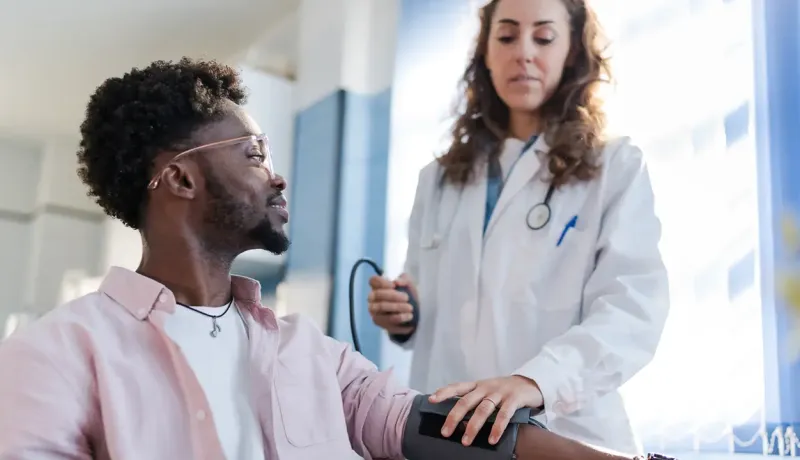 Un médecin prend la tension d'un patient dans la cadre d'une visite médicale.