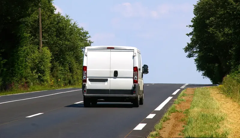 Véhicule utilitaire circulant sur une route de campagne