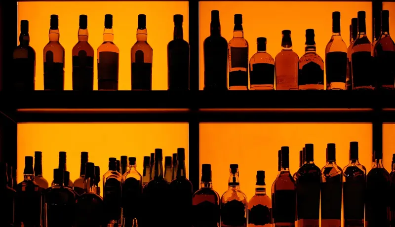 Bouteilles d'alcool posées sur des étagères d'un bar