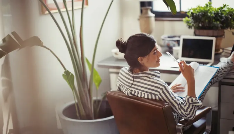 Femme utilisant un ordinateur portable à domicile.