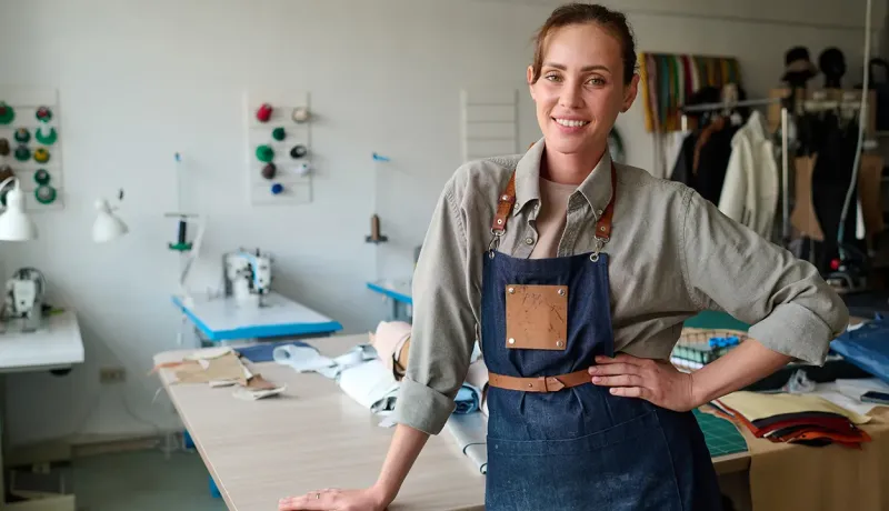 Artisane portant un tablier dans un atelier de couture.