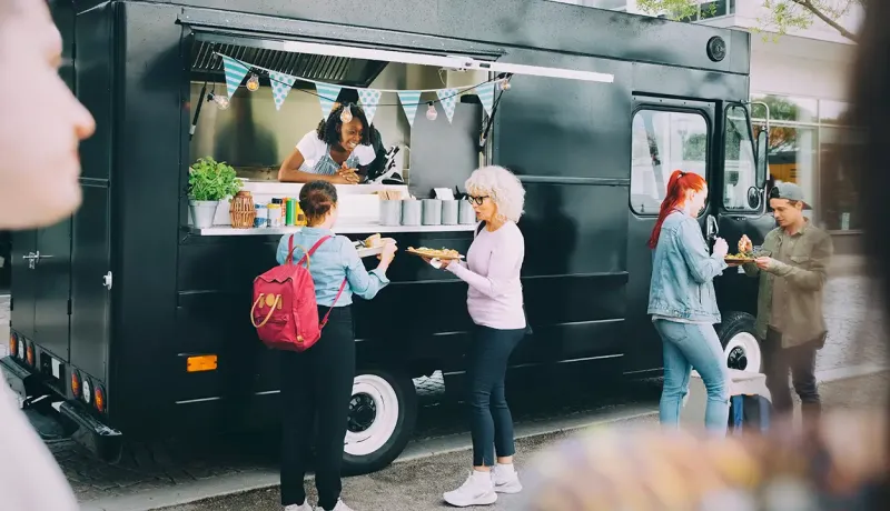 Foodtruck devant lequel plusieurs femmes passent commande